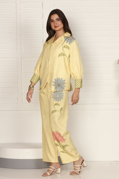 Woman wearing a light yellow embroidered outfit on a white tiled floor.